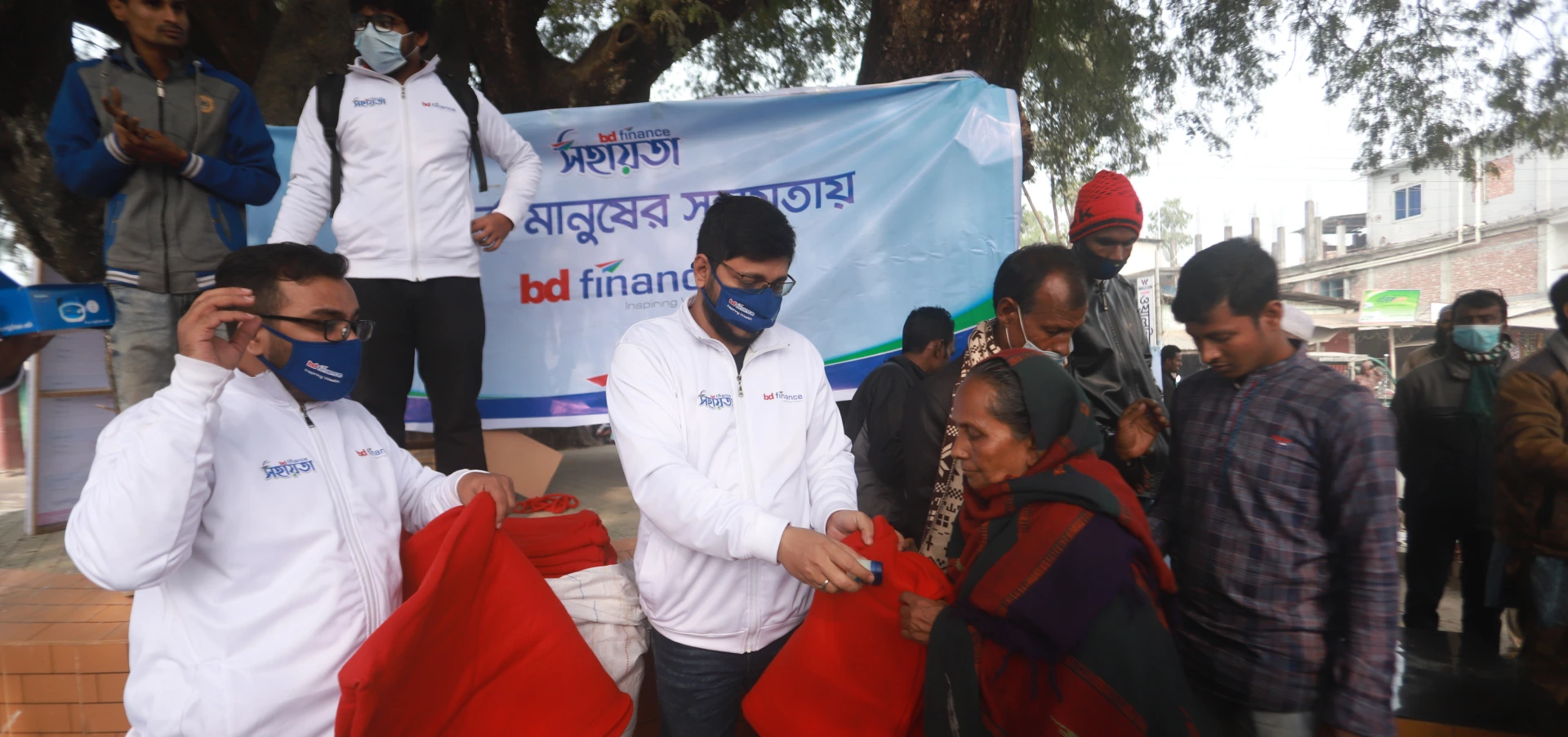 Bangladesh Finance Sahayata volunteers handing out winter blankets to people in need.
